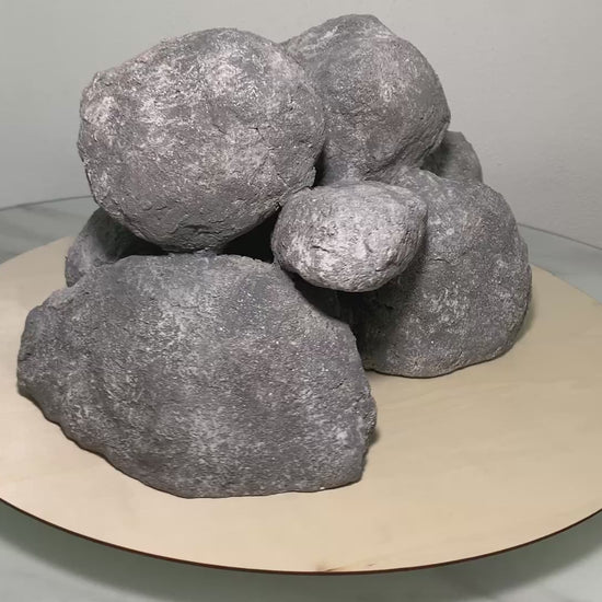 „Rotierendes Video einer grauen Aquarium-Höhlenformation aus drei verbundenen Felsen, präsentiert auf einem runden Tablett zur Ansicht der Höhleneingänge aus 360 Grad.“