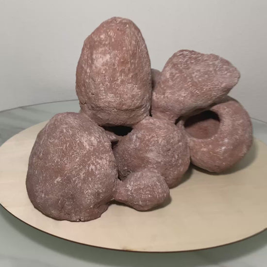 „Rotierendes Video einer braunen Aquarium-Höhlenformation aus drei verbundenen Felsen, präsentiert auf einem runden Tablett zur Ansicht der Höhleneingänge aus 360 Grad.“