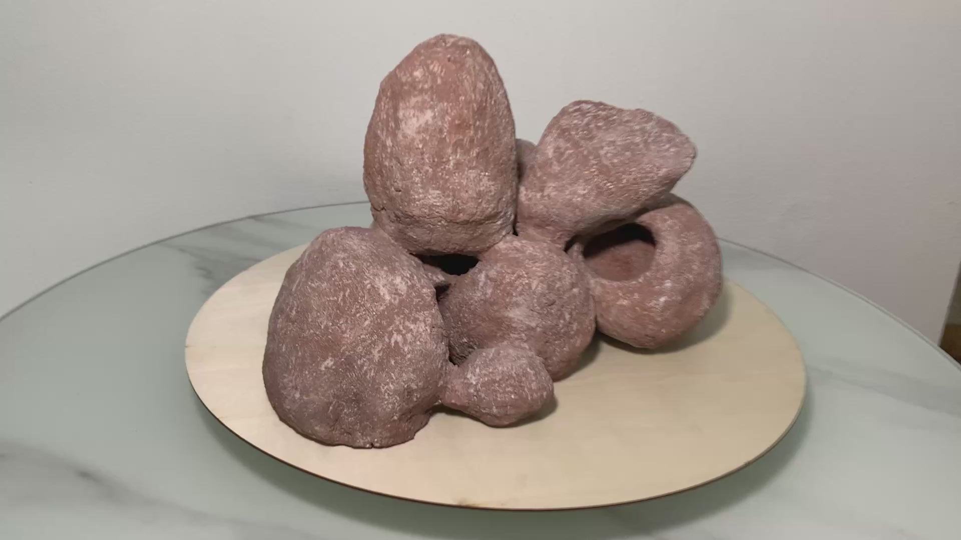 „Rotierendes Video einer braunen Aquarium-Höhlenformation aus drei verbundenen Felsen, präsentiert auf einem runden Tablett zur Ansicht der Höhleneingänge aus 360 Grad.“