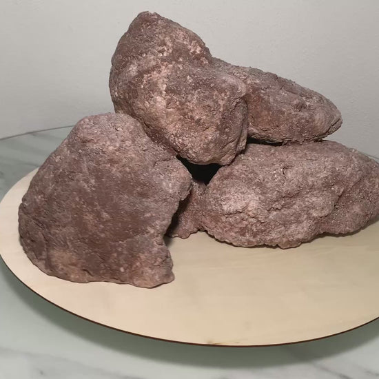 „Rotierendes Video einer braunen Aquarium-Höhlenformation aus drei verbundenen Felsen, präsentiert auf einem runden Tablett zur Ansicht der Höhleneingänge aus 360 Grad.“