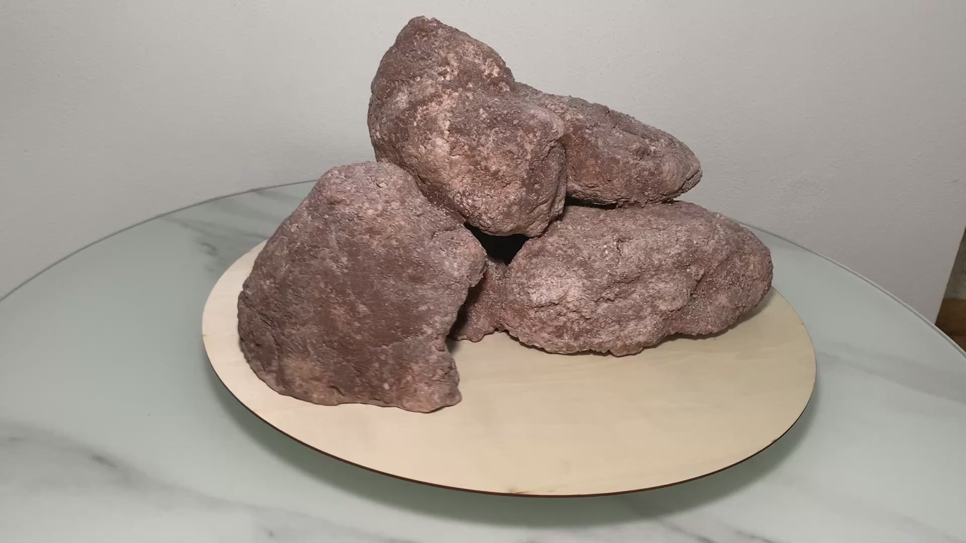 „Rotierendes Video einer braunen Aquarium-Höhlenformation aus drei verbundenen Felsen, präsentiert auf einem runden Tablett zur Ansicht der Höhleneingänge aus 360 Grad.“